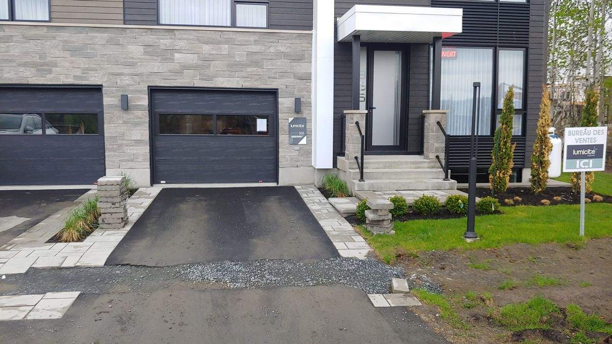 Maison modèle neuve avec bordures de pavé et allée