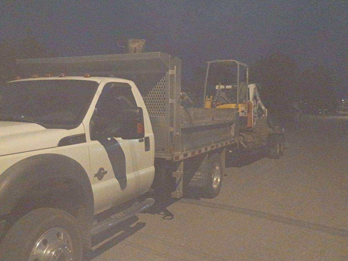 Camion et remorque LT avec la chargeuse, photographiés la nuit