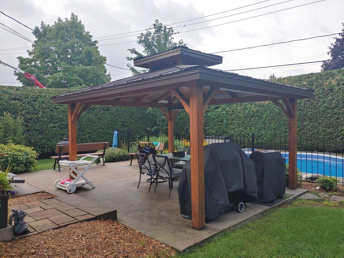 Gazebo en bois avec mobilier et coin de piscine, l'après-midi