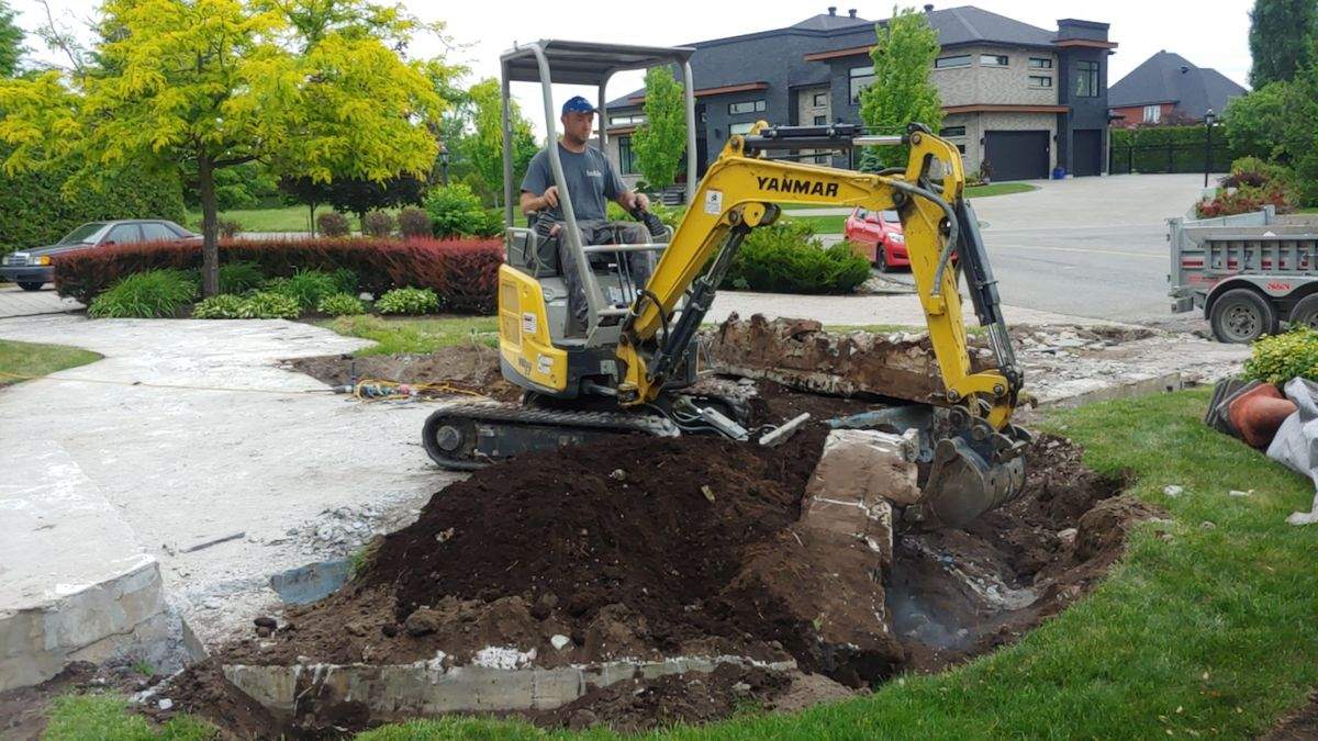 Mini-excavatrice LT en train d'excaver une cour