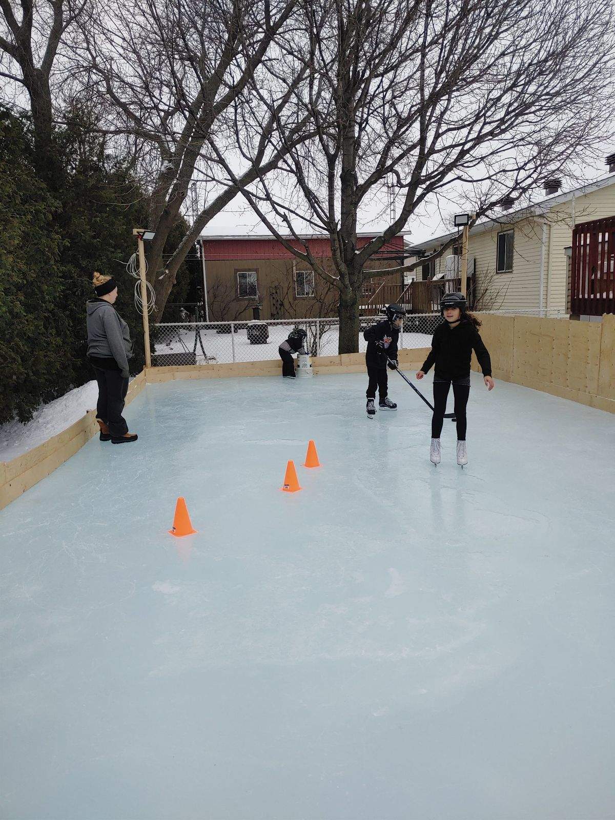 Partie improvisée sur la patinoire de cour, cônes orange sur la glace