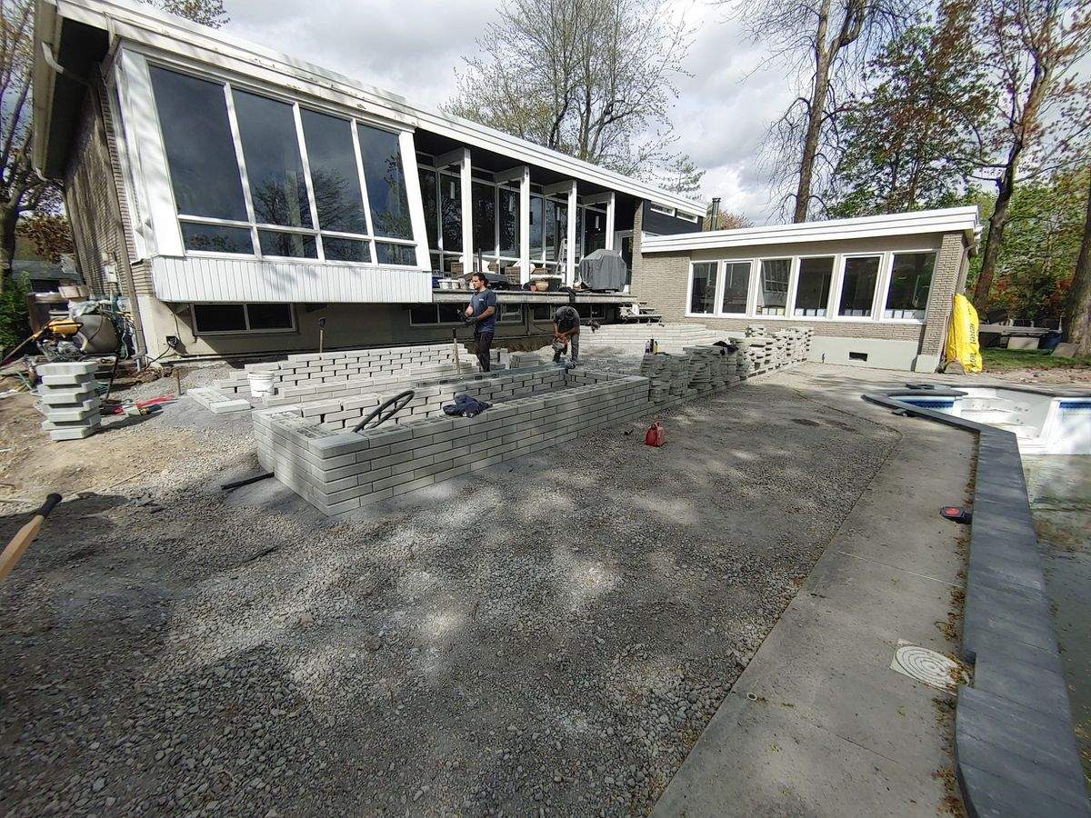 Ancien contour de piscine en béton fissuré, en démolition