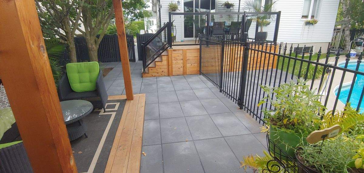 Terrasse en cèdre avec garde-corps en verre, vue dégagée sur la cour