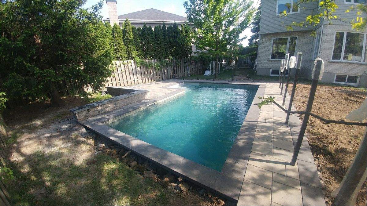 Contour de piscine rectangulaire en pavé avec bordure foncée