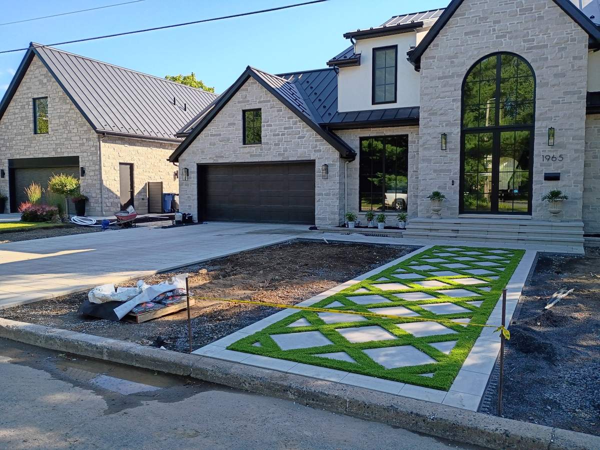 Entrée en pavé à motif diamant devant une belle maison de pierre de la Rive-Sud, réalisée par LT Terrassement