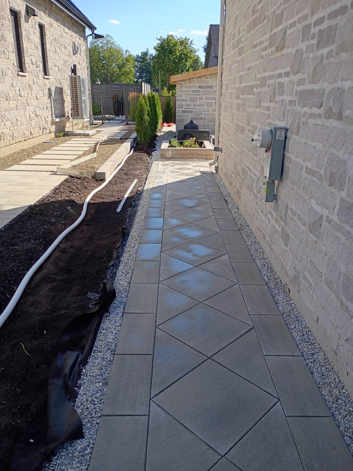 Allée en pavé à motif diamant qui mène vers la piscine