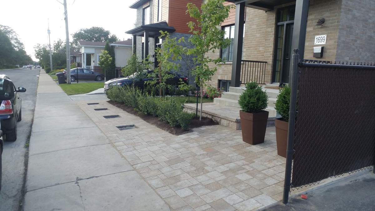 Dalle de béton sous une porte-patio, terrasse en pavé construite juste à côté