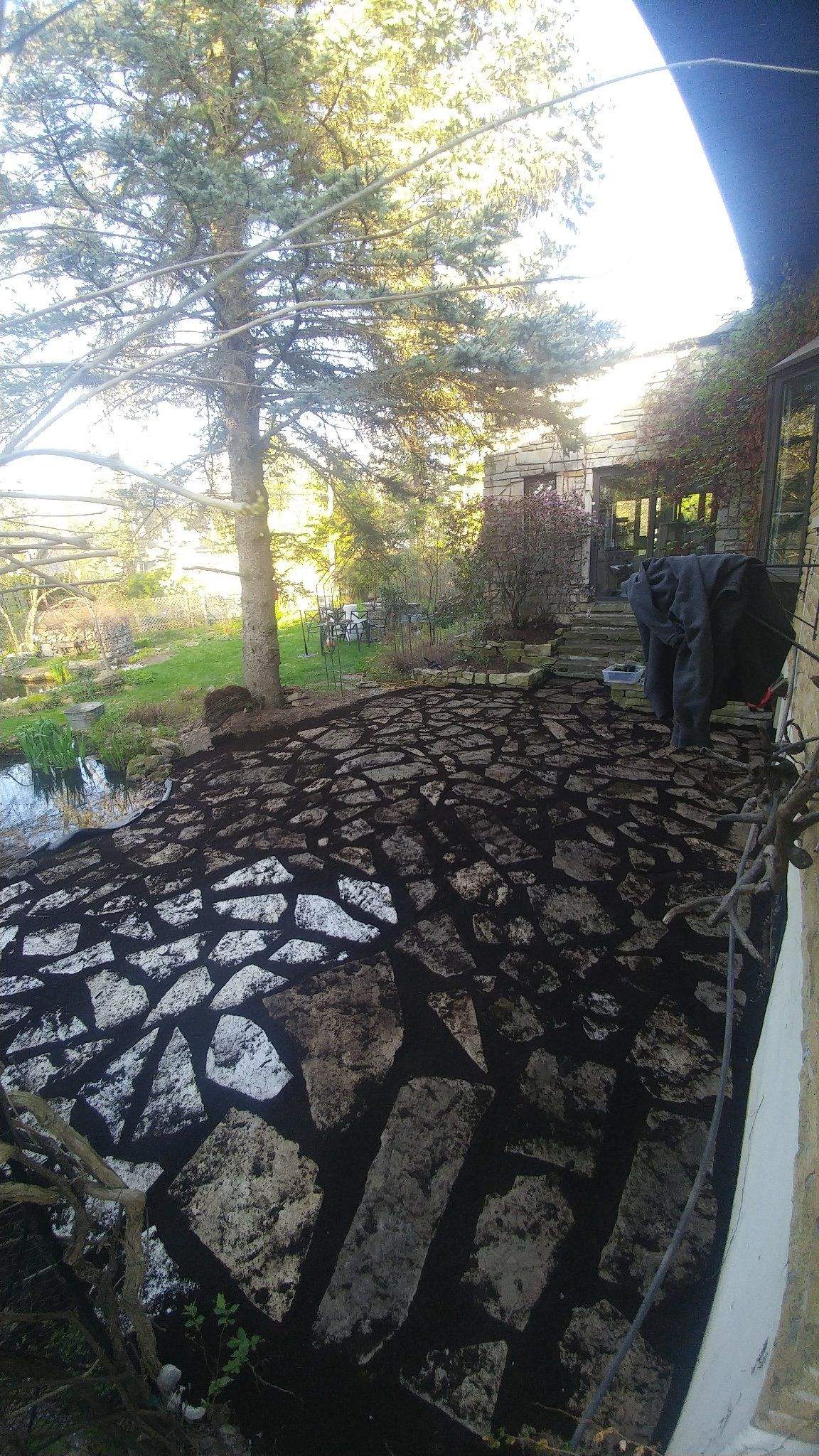 Patio en dalles naturelles relevé et reposé, joints refaits au noir