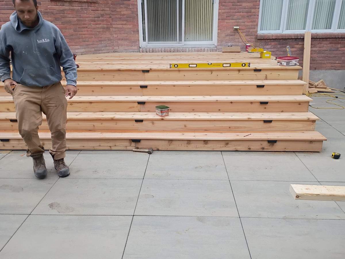 Grands escaliers de cèdre en construction, niveau jaune posé sur les marches