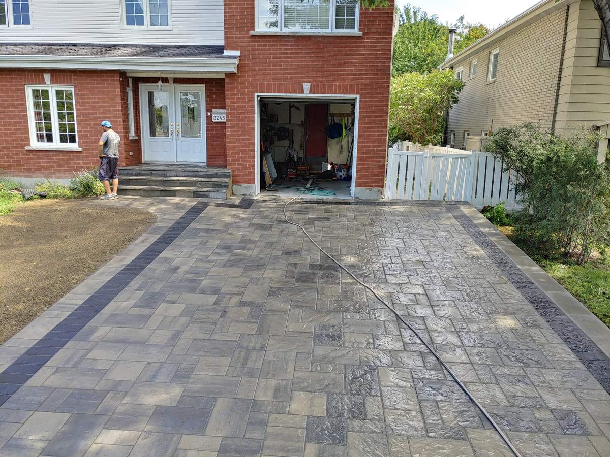 Entrée de cour en pavé gris avec bordures foncées